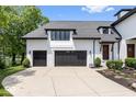 A pristine home exterior with a three-car garage and lush landscaping at 12208 Island Dr, Indianapolis, IN 46256