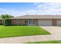 Brick exterior with well-maintained lawn, attached garage, and charming curb appeal under a clear sky at 1309 Wyoming Way, Anderson, IN 46013