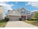 A two-story home featuring brick and siding with a two car garage and large driveway at 14453 Glapthorn Rd, Fishers, IN 46037
