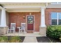 Cozy covered porch with brick pillars and rocking chairs for relaxing outdoors at 14453 Glapthorn Rd, Fishers, IN 46037