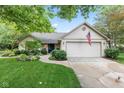 Beautifully landscaped single-story home with attached two-car garage at 1482 Waterford Dr, Zionsville, IN 46077
