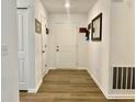 Bright entryway with hardwood flooring, white walls, and coat closet near the front door at 213 Drewood Dr, Trafalgar, IN 46181