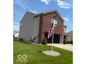 Two-story home boasts a brick and vinyl exterior, a well-kept lawn, and an American flag waving proudly at 2231 Abbey St, Brownsburg, IN 46112