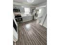 Modern kitchen with stainless steel appliances, gray cabinets, and wood floors, perfect for cooking enthusiasts at 3201 W 22Nd St, Indianapolis, IN 46222