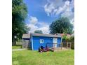 Back of house with deck, lawn mower and grassy area at 3464 N Bancroft St, Indianapolis, IN 46218