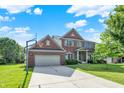 Charming brick home featuring an attached garage and basketball hoop on a sunny day at 3740 Weather Stone Xing, Zionsville, IN 46077