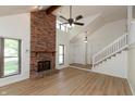 Open living room with a brick fireplace, new floors, and large windows providing ample light at 4291 Caledonia Way, Indianapolis, IN 46254