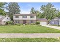 Charming brick and siding home with a well-manicured lawn and beautiful landscaping at 4431 Cranbrook Dr, Indianapolis, IN 46250