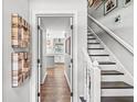 Bright hallway showcasing hardwood floors leading to the kitchen and an adjacent staircase at 4431 Cranbrook Dr, Indianapolis, IN 46250
