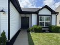 Inviting home featuring a black front door, with lush landscaping enhancing its curb appeal at 4726 Deacon Ln, Indianapolis, IN 46237
