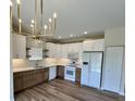 Modern kitchen with sleek appliances, hardwood floors, and stylish white and wood cabinetry at 4726 Deacon Ln, Indianapolis, IN 46237