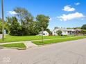 Quaint white home with blue porch, lush front lawn, and street view creating a welcoming curb appeal at 528 W Mechanic St, Shelbyville, IN 46176