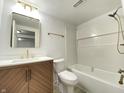 Modern bathroom with dark wood vanity, gold fixtures, and shower-tub combo with white tiled walls at 602 S Sherman Dr, Indianapolis, IN 46203
