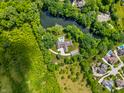Expansive aerial view of the property showcasing a private pool, lush surroundings, and proximity to the lake at 6115 Stonegate Run, Zionsville, IN 46077