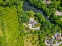 Stunning aerial view of a modern home with a private pool surrounded by lush greenery and a serene pond at 6115 Stonegate Run, Zionsville, IN 46077