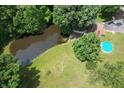 Beautiful aerial view of the property with a pond and above-ground pool surrounded by trees at 6295 State Road 142 Rd, Martinsville, IN 46151
