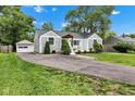 Charming home with a long driveway, well-maintained landscaping, and a detached garage at 6741 Evanston Ave, Indianapolis, IN 46220