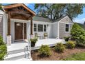 Inviting front porch with stylish seating, a beautifully stained wood door, and stone accents at 6741 Evanston Ave, Indianapolis, IN 46220