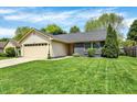 Attractive single-story home with manicured lawn, a two-car garage, and complemented by mature landscaping at 6838 Cherry Laurel Ln, Fishers, IN 46038