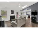 Bright, open living room with fireplace, vaulted ceilings, skylight and seamless flow into kitchen area at 6838 Cherry Laurel Ln, Fishers, IN 46038