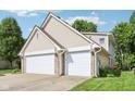 Exterior showcasing the home's vinyl siding, brick accents, and a convenient two-car garage, complemented by the well-maintained landscaping at 829 Pioneer Woods Dr, Indianapolis, IN 46224
