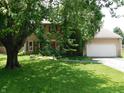Inviting two-story home with a large yard, a prominent tree, and a cozy aesthetic at 8425 E 82Nd E St, Indianapolis, IN 46256