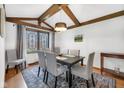 Dining room featuring wood beam ceiling, decorative chandelier, and window views at 8525 Winding Ridge Rd, Indianapolis, IN 46217