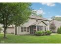 A spacious backyard features mature trees, a covered porch, and a well-maintained lawn, perfect for outdoor activities at 9643 Cypress Way, Carmel, IN 46032