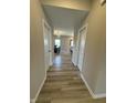 Hallway showcases clean neutral paint and wood-look floors leading into an adjacent dining room at 10218 Arctic Edge Dr, Indianapolis, IN 46259