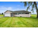 Inviting home with a large front yard and attached garage, surrounded by greenery at 10500 S County Road 200 W, Muncie, IN 47302