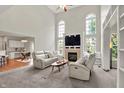 Open-concept living room with fireplace, large windows, and comfortable seating at 13757 Flintridge Pass, Carmel, IN 46033