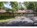 Picturesque home exterior with a paved driveway, lush trees, and a well-maintained front yard at 14407 Bryn Mawr Dr, Fishers, IN 46038
