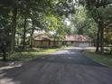 Scenic home exterior with a long driveway, mature trees, and a combination of stone and siding at 14407 Bryn Mawr Dr, Fishers, IN 46038
