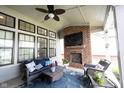 Relaxing covered patio with brick fireplace, TV, and comfortable seating at 1580 Mairn Ave, Carmel, IN 46032