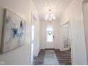 Bright foyer with elegant chandelier, artwork, and wood-look flooring at 1580 Mairn Ave, Carmel, IN 46032