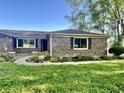 A well-maintained brick home with a curved walkway and lush landscaping, offering curb appeal at 15841 E 265 N, Columbus, IN 47203