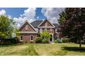 Beautiful two-story brick home with a manicured lawn, landscaping, and a classic architectural design at 15920 Oak Park Ct, Westfield, IN 46074