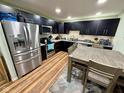 Modern kitchen featuring stainless steel appliances, dark cabinetry, and a dining area with seating at 1816 Hemlock Ln, Plainfield, IN 46168