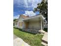 Modest home featuring a front porch, boarded windows, and vinyl siding at 1902 Orange St, Indianapolis, IN 46203