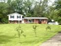 Charming two-story home with brick accents, white siding and black shutters on a large lawn at 2615 Alexandria Pike, Anderson, IN 46012