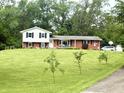 Charming two-story home with brick accents, white siding and black shutters on a large lawn at 2615 Alexandria Pike, Anderson, IN 46012