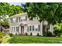 Charming two-story home with a well-manicured lawn and lush landscaping at 4904 N Washington Blvd, Indianapolis, IN 46205