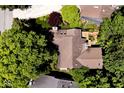 Overhead shot of a home with a brown roof, well-manicured backyard landscaping, and deck surrounded by tall trees at 5240 Windridge Dr, Indianapolis, IN 46226