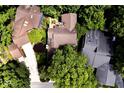 Aerial view of a private home surrounded by lush trees showcasing a wooden deck, landscaping, and private driveway at 5240 Windridge Dr, Indianapolis, IN 46226