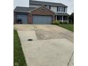 This home features a wide driveway and attached two car garage at 6027 Moonseed Cir, Indianapolis, IN 46203