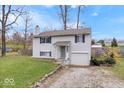 Charming two-story home with light siding, blue shutters, covered entryway and attached one car garage at 6120 E Southport Rd, Indianapolis, IN 46237