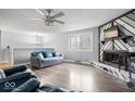 Spacious living room with hardwood floors, ceiling fan, large window and decorative fireplace at 6120 E Southport Rd, Indianapolis, IN 46237