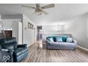 Open concept living area showcasing wood floors, a modern ceiling fan, and a comfortable seating arrangement at 6120 E Southport Rd, Indianapolis, IN 46237