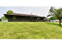 The backyard features a gentle slope, a well-maintained lawn, and the house's rear facade at 6851 Azalea Dr, Indianapolis, IN 46214