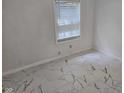 Clean and simple bedroom design with modern marble tile flooring and white walls for a minimalist aesthetic at 7831 E 46Th St, Indianapolis, IN 46226